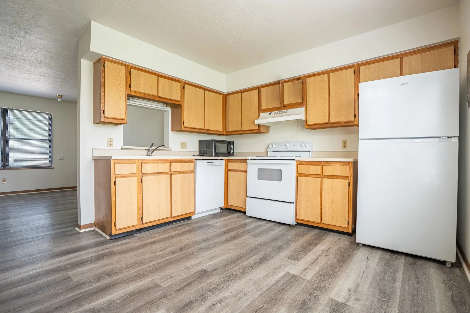 Kitchen with wood cabinets and white appliances at Center Place Apartments, Greenfield