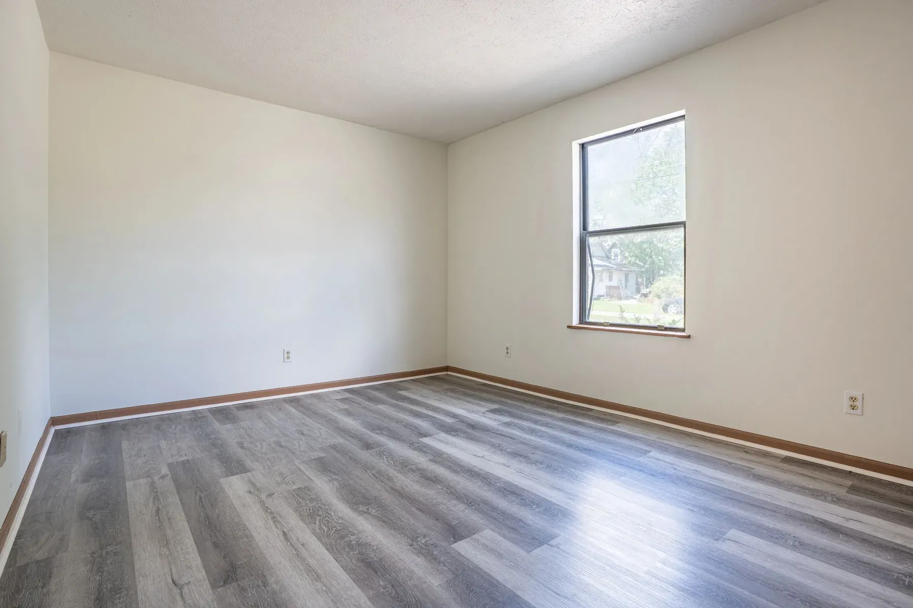 Living room with a large window and neutral paint at Center Place Apartments, Greenfield