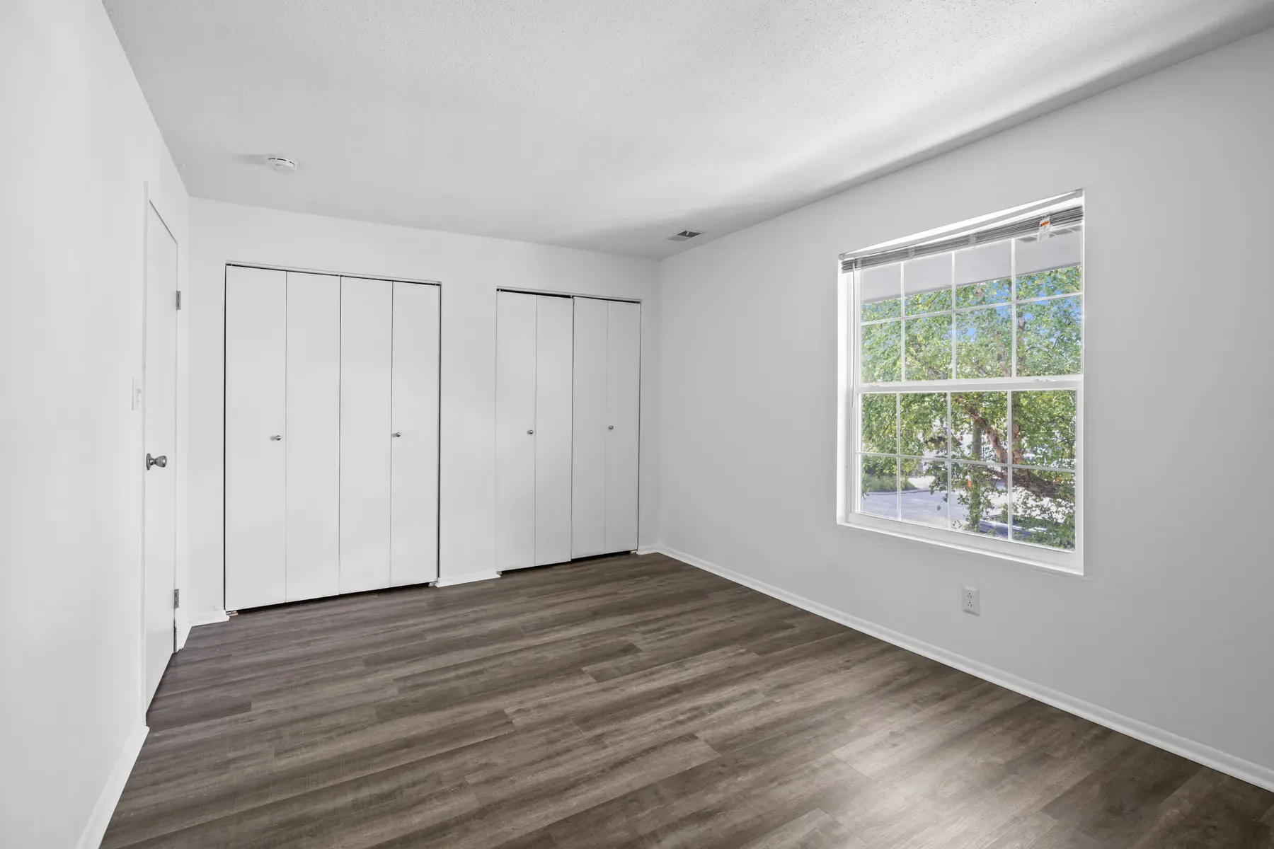 Bedroom with two white closets and a large window