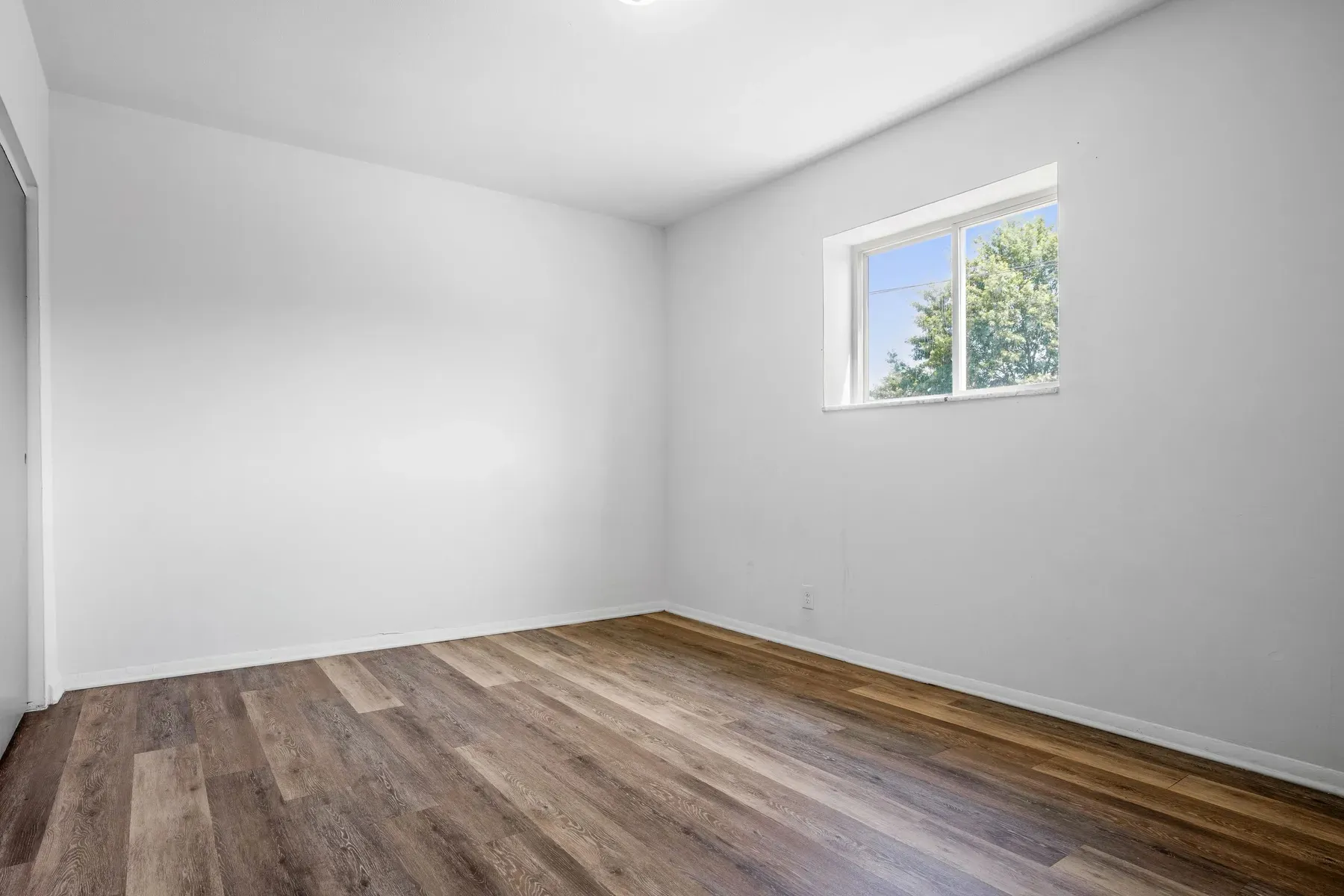 Bedroom with a window and wood-look flooring