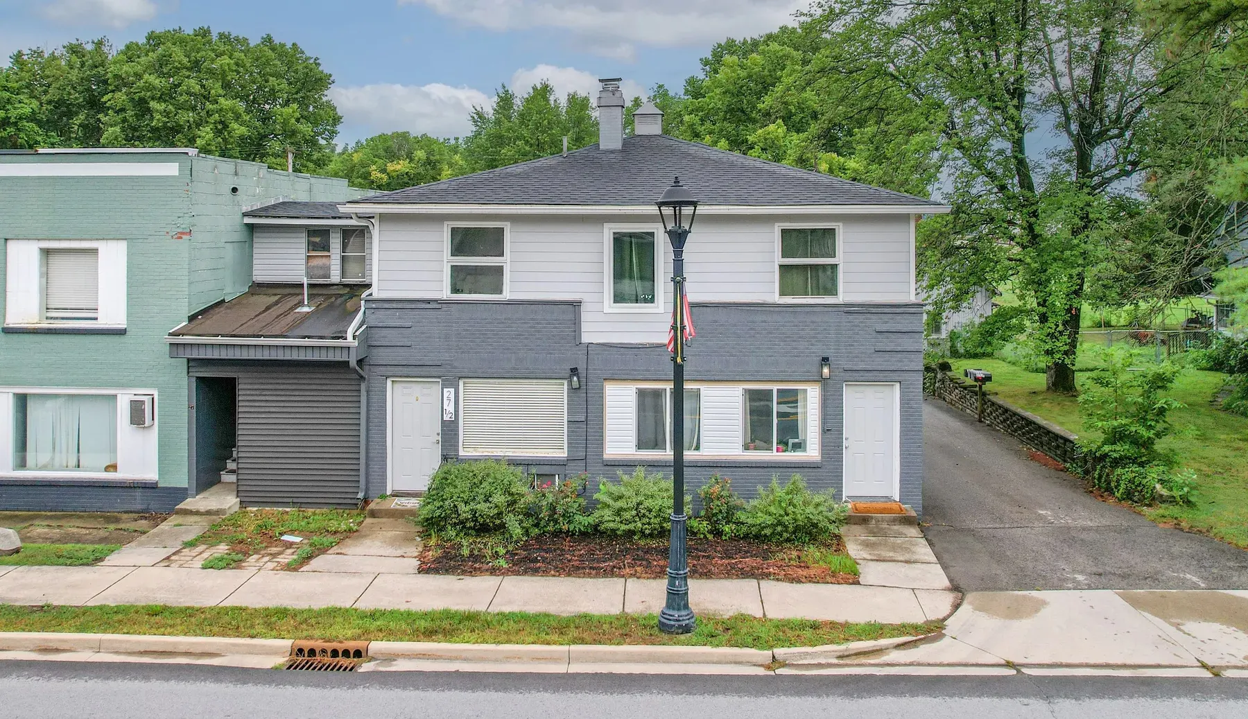 New Palestine Apartments, New Palestine: two-story gray brick and white siding building with a streetlamp out front